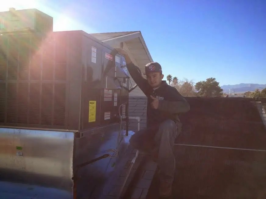 HVAC technician performing AC Tune-Up on a rooftop unit in Snohomish